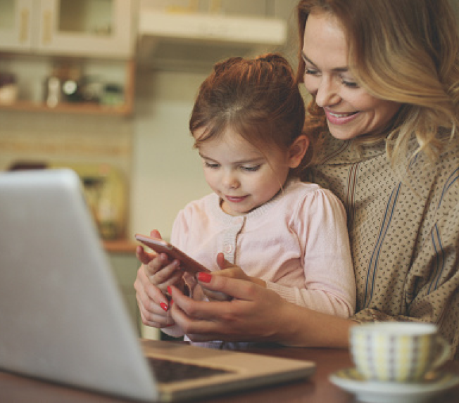 A lady and a child glancing at a phone